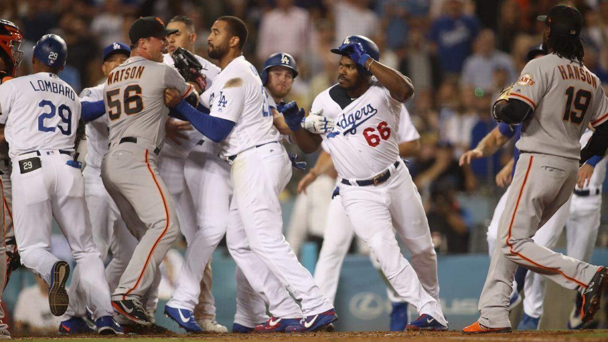 Dodgers and San Francisco Giants teammates step in after Dodgerts outfielder Yasiel Puig (66) shoved Giants catcher Nick Hundley (far left) at the plate in the bottom of the seventh inning on Tuesday.