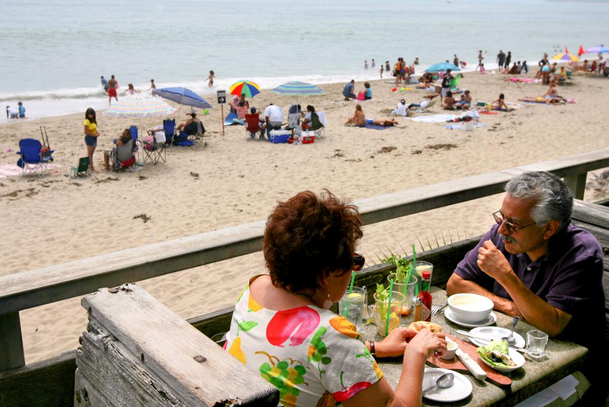 Two customers sit on the deck at Gladstone's in Pacific Palisades, overlooking the beach.