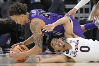 Furman forward Jalen Slawson (20) and Virginia guard Kihei Clark (0) dive on the floor for a loose ball.