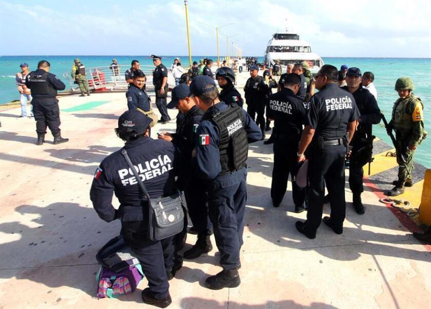 Policías Federales vigilan una embarcación el miércoles 21 de febrero de 2018, en Playa del Carmen Quintana Roo (México). EFE/Archivo