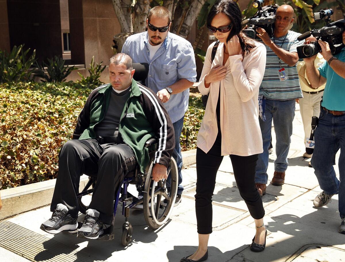 Bryan Stow, assisted by a caregiver, and family members leave the Los Angeles County Superior Courthouse.