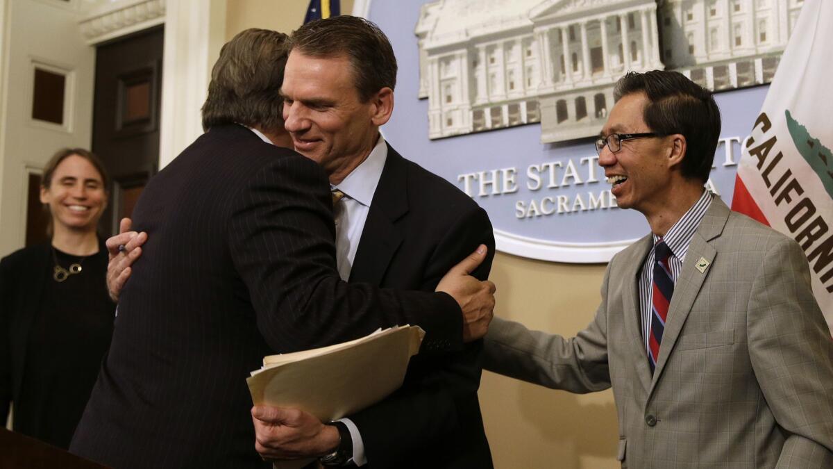State Sen. Bob Hertzberg (D-Van Nuys), left, and Assemblyman Ed Chau (D-Arcadia), right, celebrate with Alastair Mactaggart, center, after the Legislature approved their data privacy bill June 28.