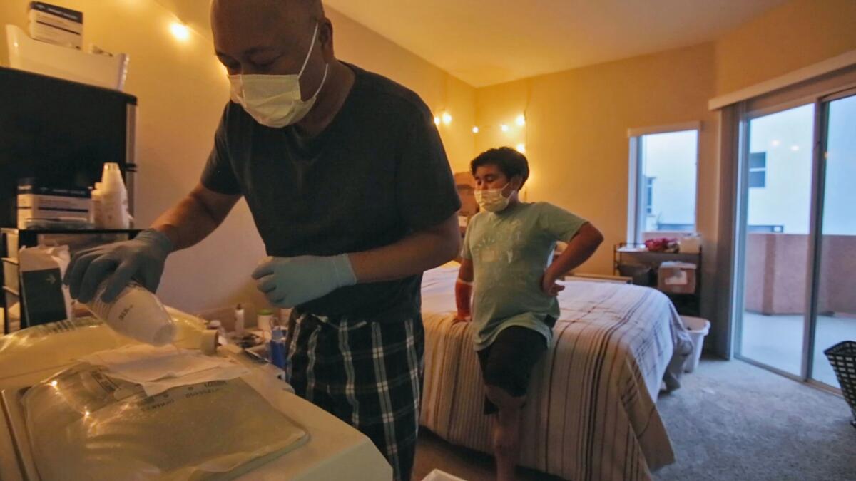 Binh Nguyen and his son Garret prepare the last dialysis treatment the night before his kidney transplant surgery.