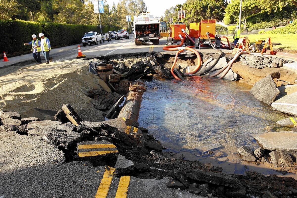 Work crews assess the damage at the site of the massive water main break on Sunset Boulevard by UCLA.