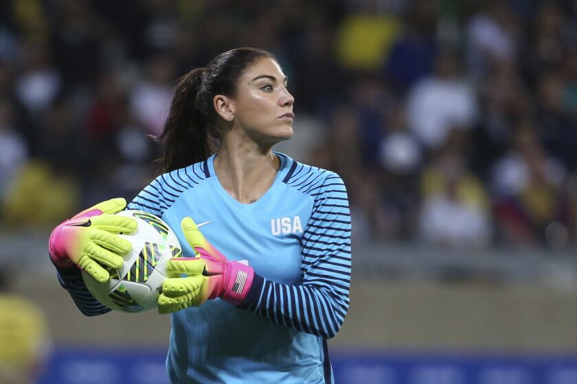 FILE - United States' goalkeeper Hope Solo takes the ball during a women's soccer game.