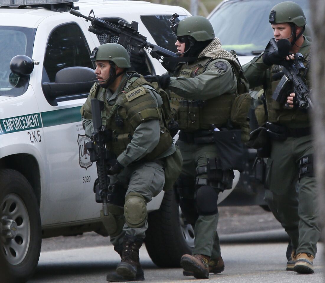 SWAT officers move toward a home on Club View Drive in Big Bear Lake as the manhunt continues for Christopher Jordan Dorner. A truck believed to be his was found burning in a remote area near a ski resort, authorities said.