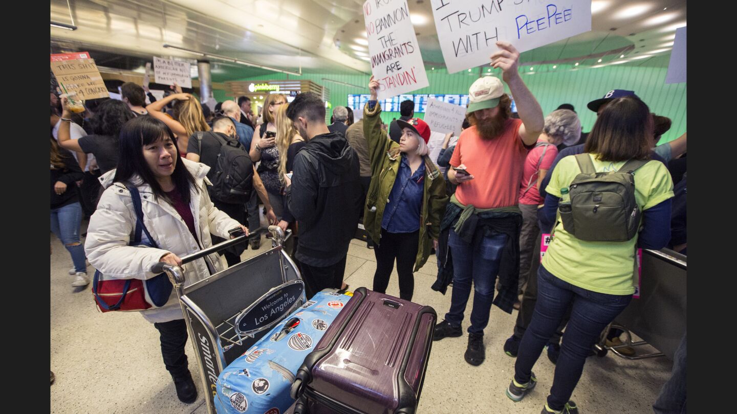 A traveler tries to get by protesters at the Tom Bradley International Terminal.