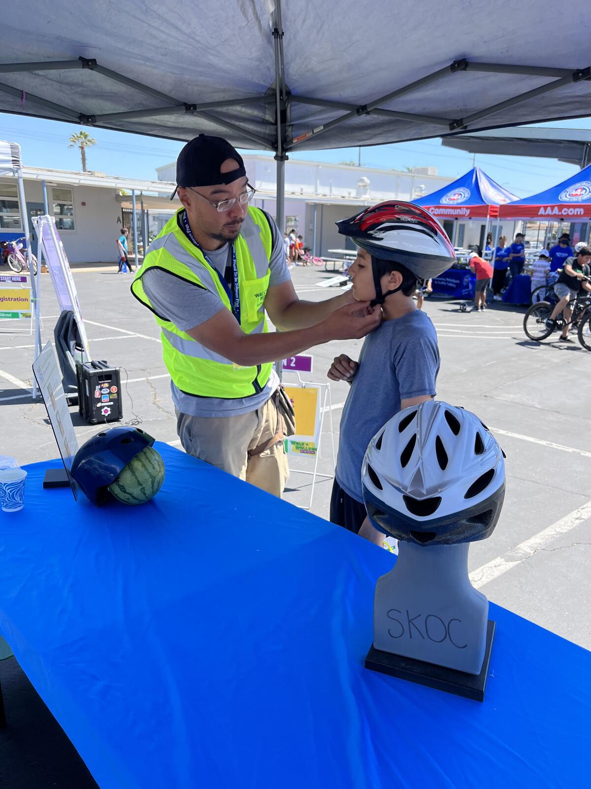 A young rider is fitted for a helmet at a 2022 bike safety event in Costa Mesa.