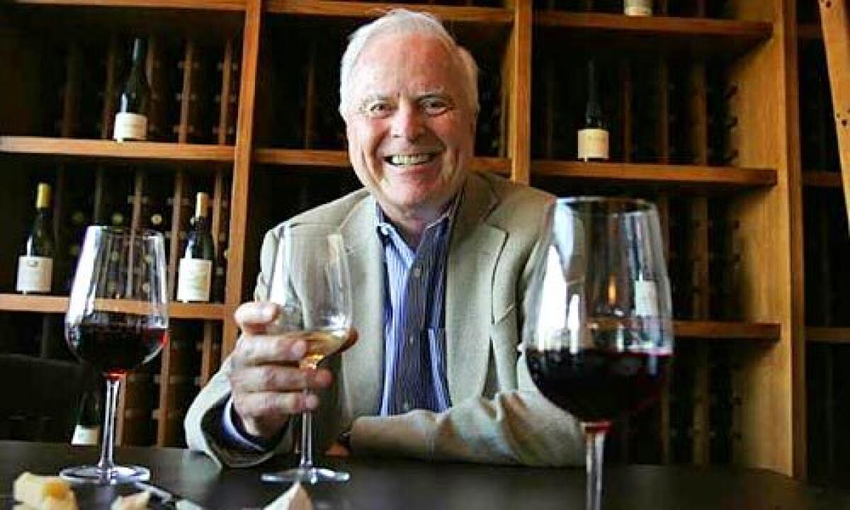 Richard Riordan, smiling, holds a glass of wine