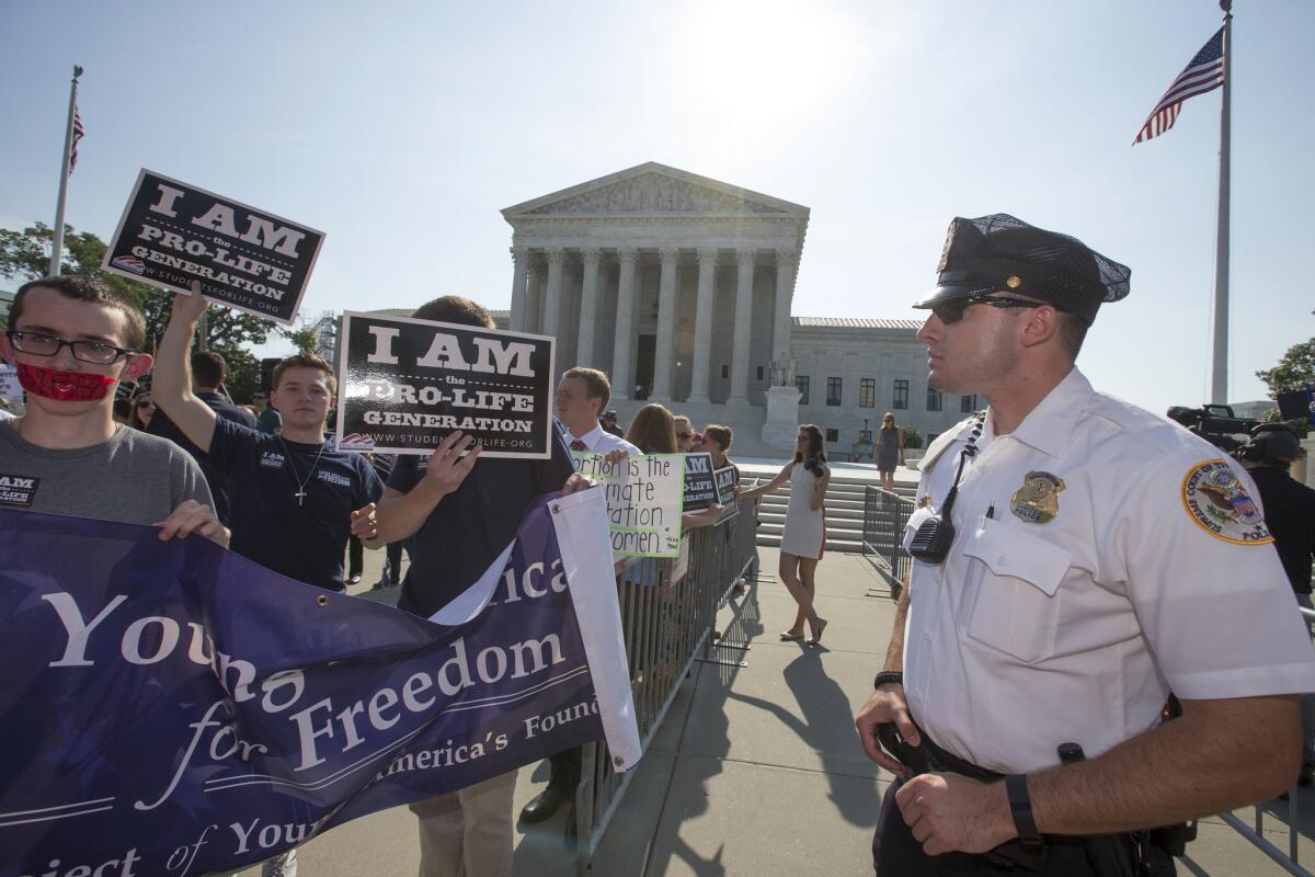 Activists demonstrate in front of the Supreme Court as the justices close out the term on Monday.