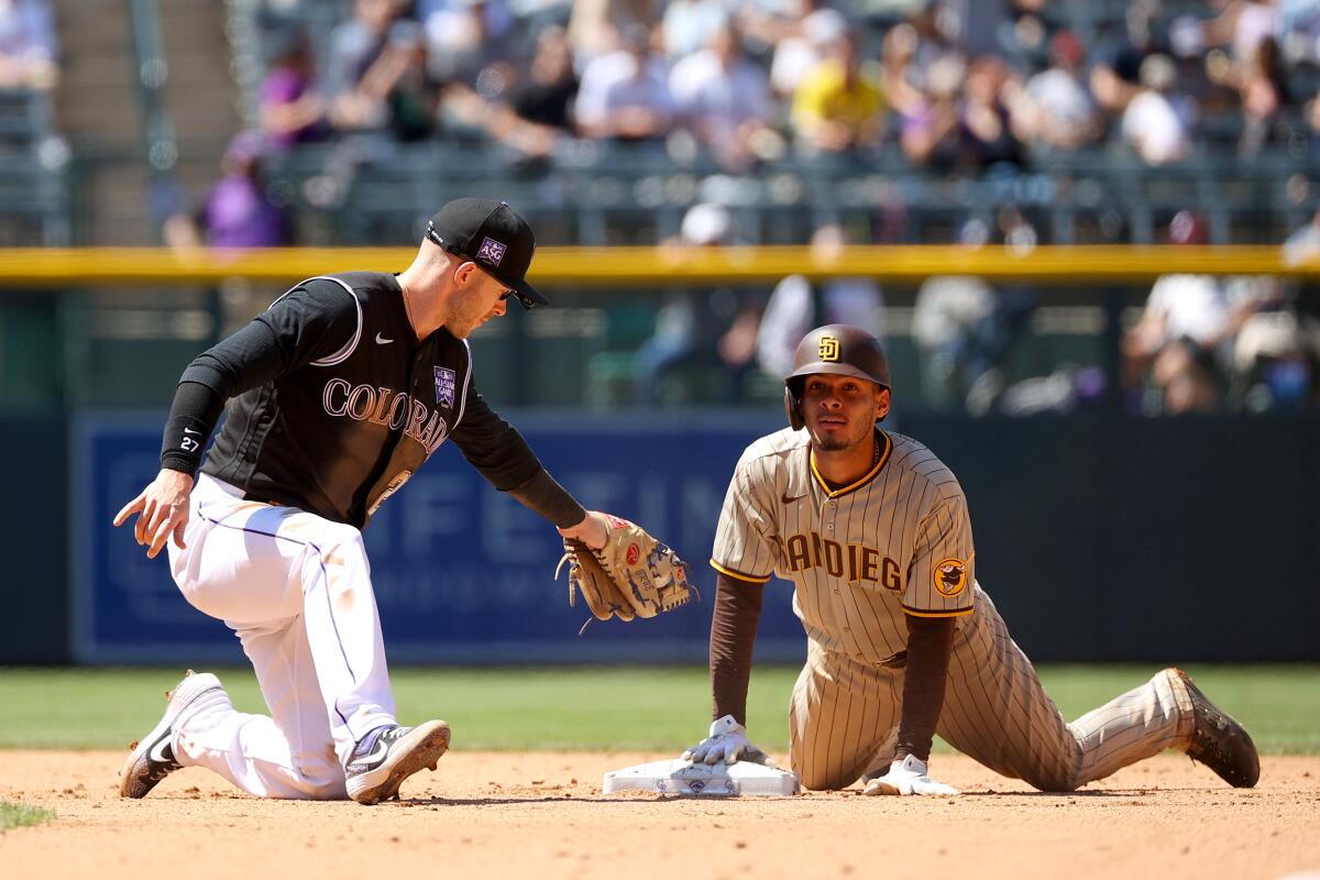 The Padres' Tucupita Marcano slides safely into second base ahead of a tag by Rockies shortstop Trevor Story on Wednesday.