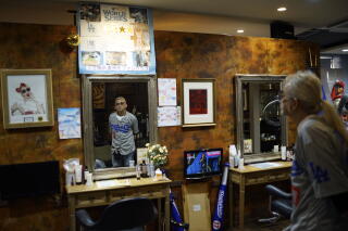 A man is reflected in a beauty salon mirror.