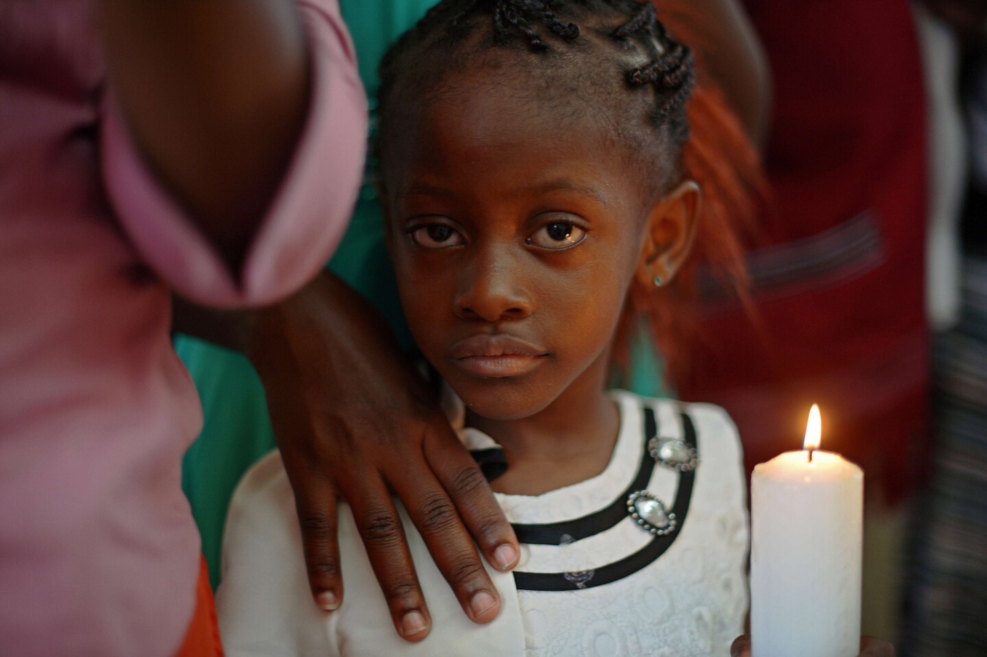 A girl holds a candle during Easter service at the Catholic cathedral in Garissa, where worshipers mourned victims of last week's massacre.