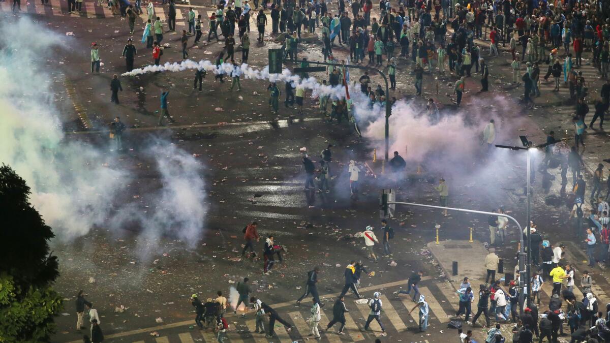 Police in Buenos Aires use a water canon and fire tear gas at groups of people hurling rocks and vandalizing stores following Argentina's loss to Germany in the World Cup final on Sunday.