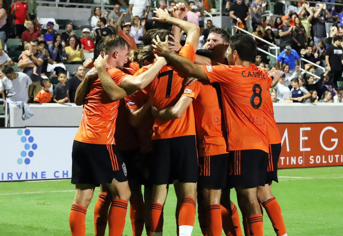 Orange County SC players celebrate after Milan Iloski (7) scores the first goal of the game against San Antonio FC.