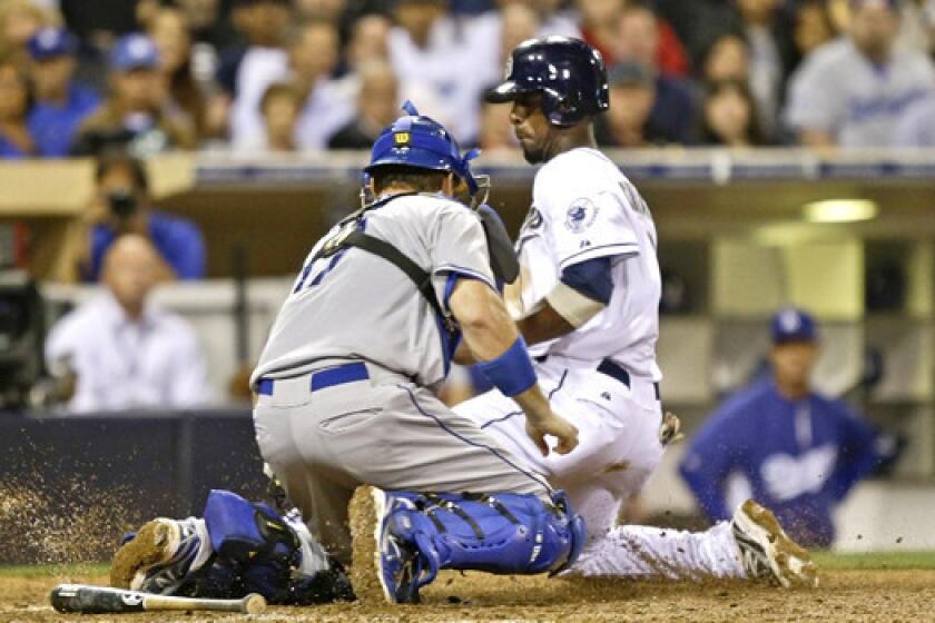 A.J. Ellis tags out Pedro Ciriaco at the plate during the Dodgers' loss to the San Diego Padres, 6-3.