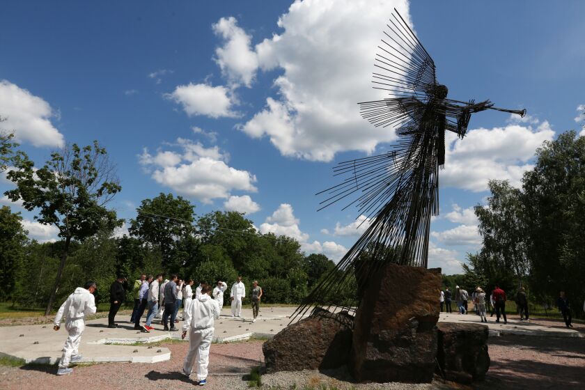 A group of foreign tourists at the Wormwood Memorial in the Chernobyl Exclusion Zone. "The third angel sounded his trumpet, and a great star, blazing like a torch, fell from the sky on a third of the rivers and on the springs of water â the name of the star is Wormwood. A third of the waters turned bitter, and many people died from the waters that had become bitter". Revelation 8:10-11. In the ancient language of the tribes living in this area in the old times wormwood was translated as chernobyl. Photo by Sergei L. Loiko for The Times. For "Chernobyl. Untold Story" story by Sergei L. Loiko