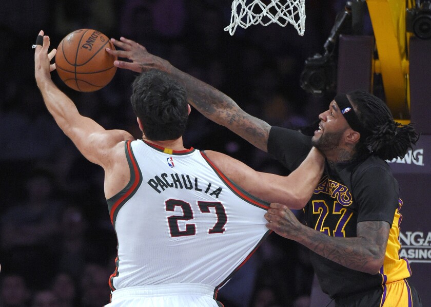 Lakers center Jordan Hill battles Bucks center Zaza Pachulia for a rebound in the first half.
