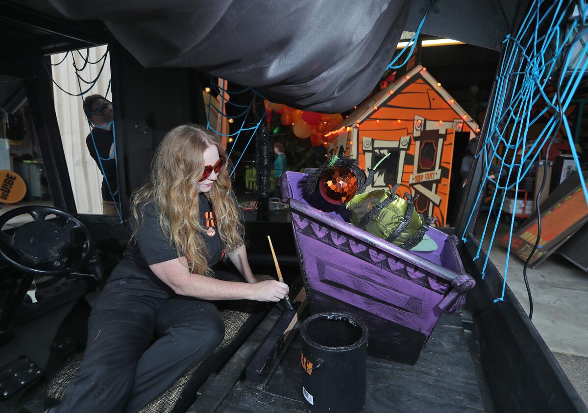 Janey Ellis paints a deceased fly's coffin for the Spider Hearse float.