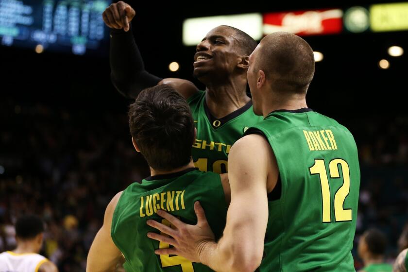 Oregon's Johnathan Loyd (10), Nicholas Lucenti (4) and Coleton Baker (12) celebrate the Ducks' win over UCLA in the Pac-12 championship game Saturday in Las Vegas.