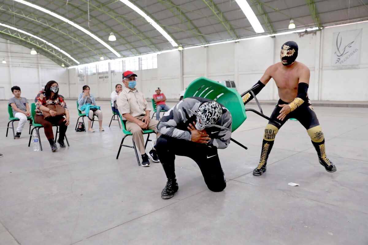 Mexican wrestler Gran Toro takes a chair to the back from Azteka Negro