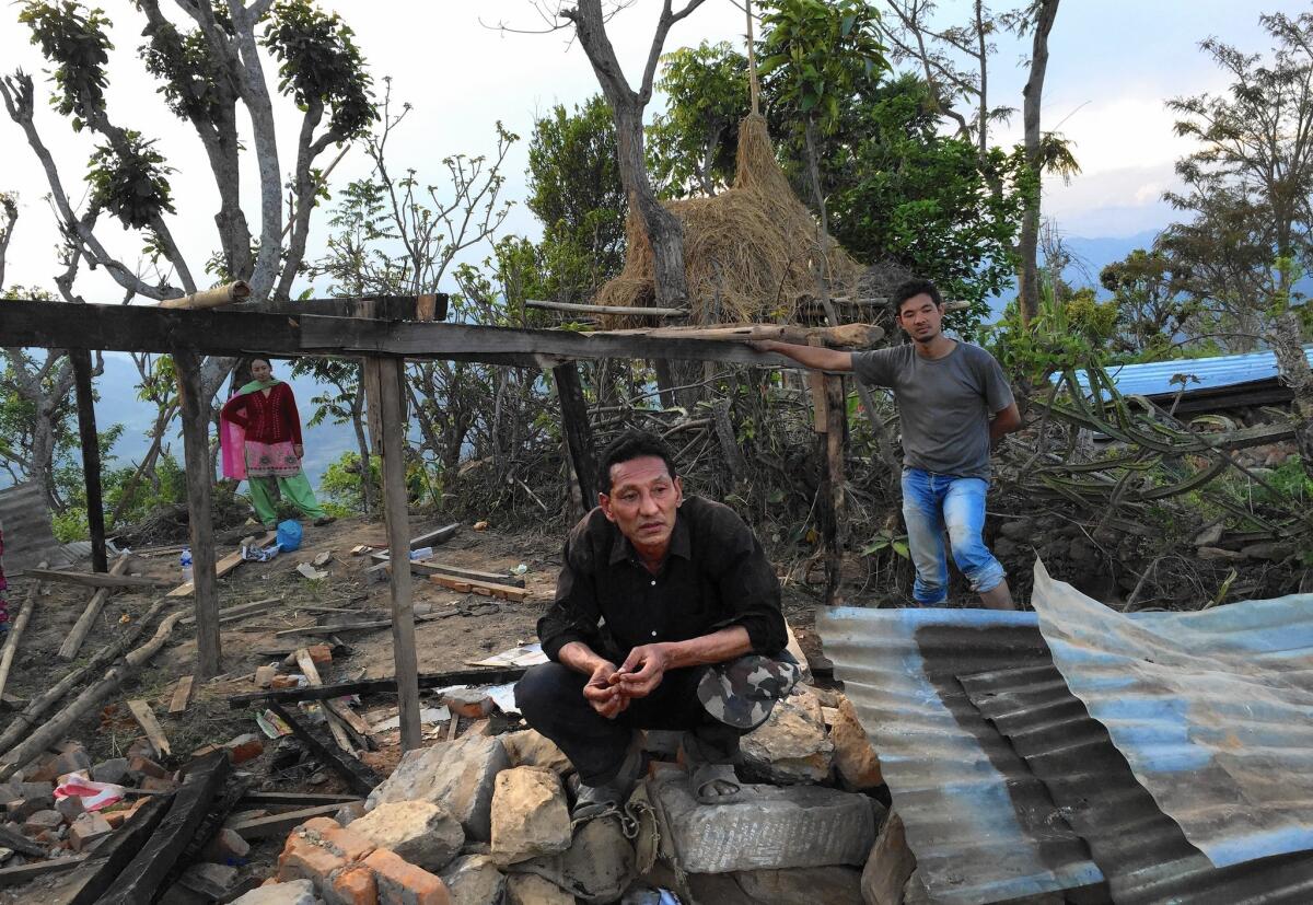 Raj Kumar Sahi, center, with son Sujan in the rubble of their home in Paslang, about 12 miles from the epicenter of the April 25 earthquake in Nepal.
