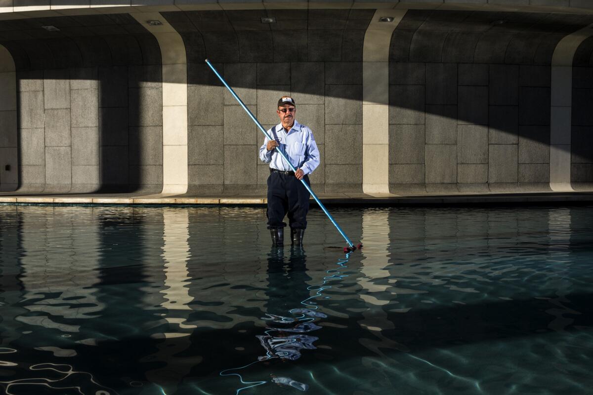 Jose Quintaro, who has been a gardener at the Music Center for 23 years, is photographed in the fountain of the Mark Taper Forum. He starts early - 4:30 a.m. - to get the grounds ready when the curtain rises each day.