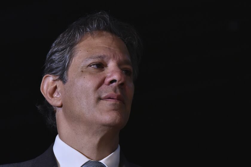 Former Sao Paulo Mayor Fernando Haddad listens to Brazil's President-elect Luiz Inacio Lula da Silva, during a press conference at Da Silva's transition team headquarters in Brasilia, Brazil, Friday, Dec.9 2022. Lula da Silva revealed on Friday some of the faces that will compose his future administration, starting Jan. 1, including his much-awaited pick for Finance Minister: Haddad. (AP Photo/Ton Molina)