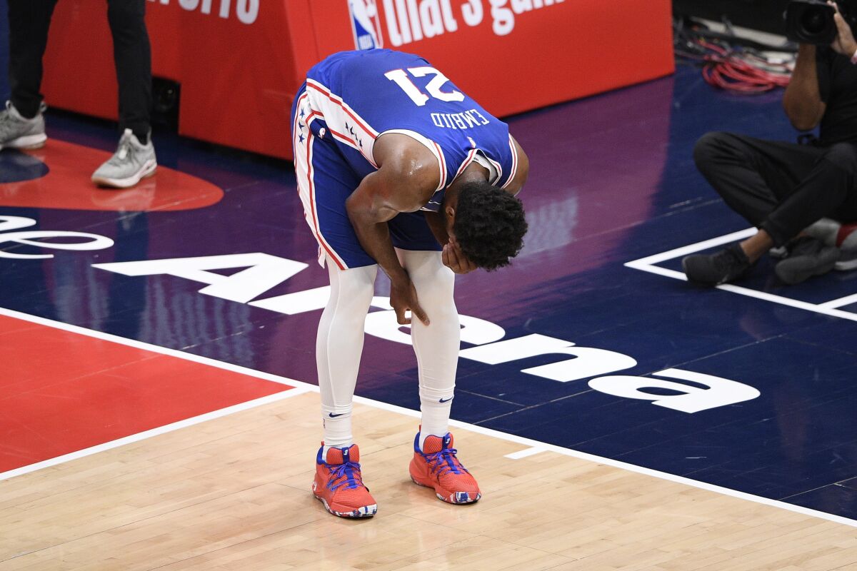 Philadelphia 76ers center Joel Embiid reacts after sustaining a knee injury during the first quarter.
