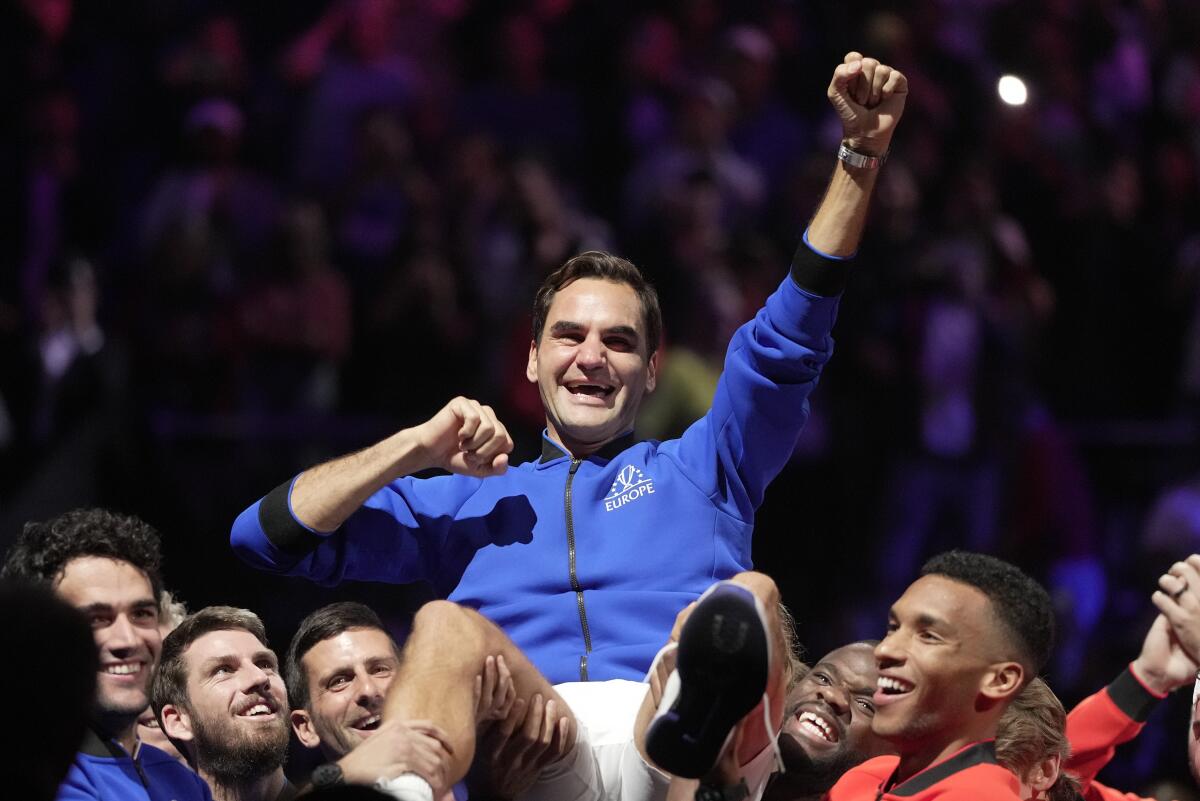 Roger Federer is lifted by fellow players after playing with Rafael Nadal in a Laver Cup doubles match Friday.