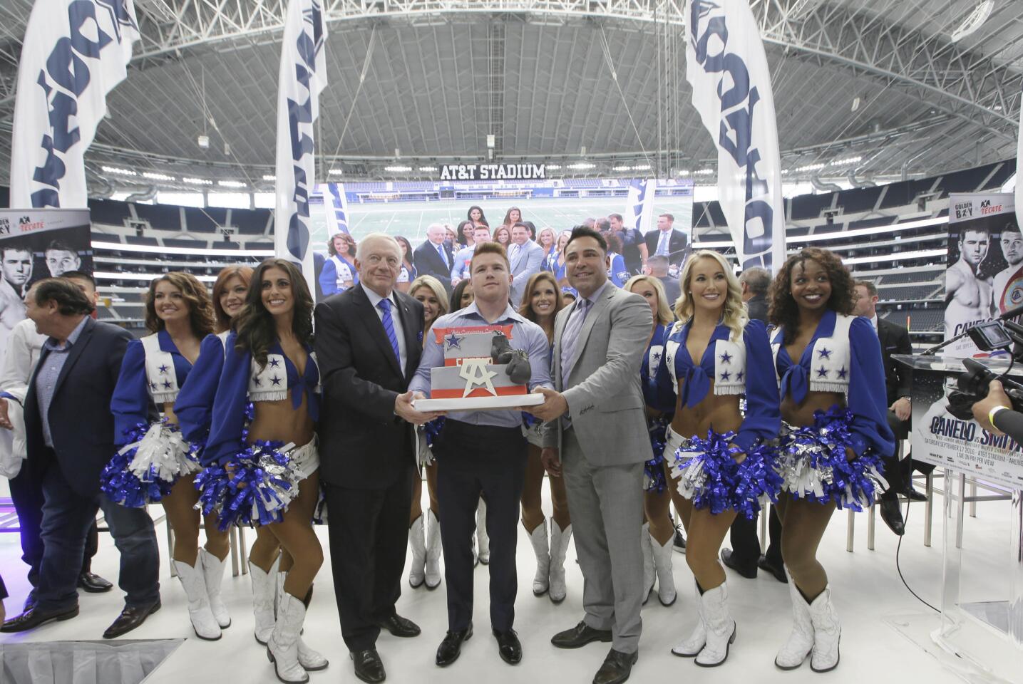 Canelo Alvarez, center, poses with a birthday cake presented to him by Dallas Cowboys owner Jerry Jones, left, and Oscar De La Hoya during a news conference promoting a fight between Alvarez and Liam Smith in Arlington, Texas, Monday, July 18, 2016. Alvarez and Smith will fight for the BBO Junior Middleweight Championship on Saturday, Sept. 17, 2016. (AP Photo/LM Otero)