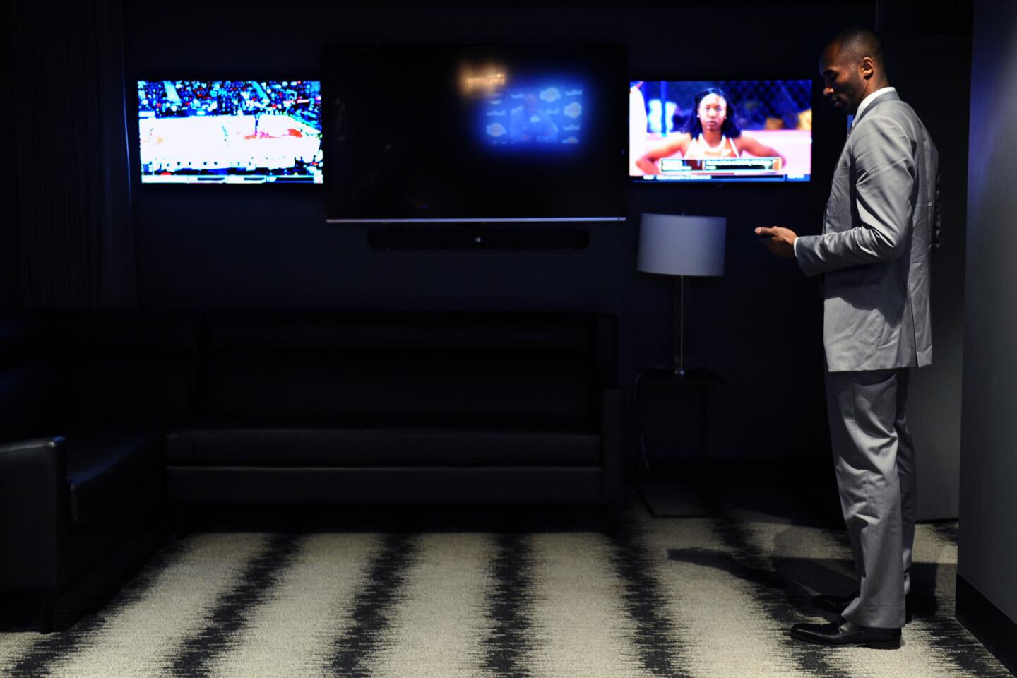 Lakers Kobe Bryant looks at his phone as he waits for guests in a private room before a game with the Knicks at the Staples Center.