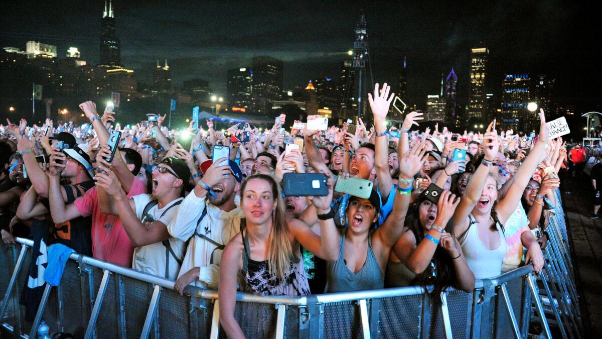 Concertgoers on Aug. 5 at the Lollapalooza music festival in Chicago's Grant Park, across the street from where Las Vegas shooter Stephen Paddock may have booked a hotel room that same weekend.