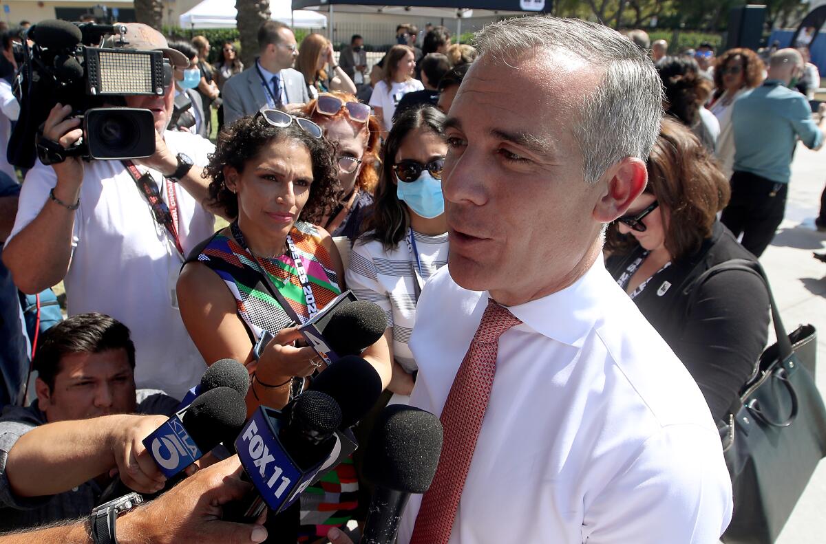 Mayor Eric Garcetti talks to reporters at Exposition Park. 