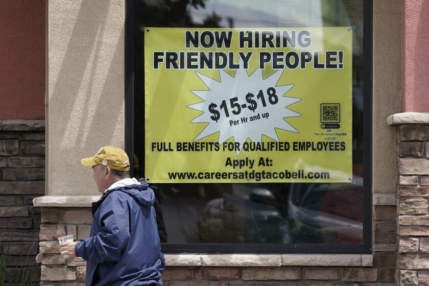 Starting wages are advertised on a sign in the window of a Taco Bell in Sacramento, Calif., Monday, May 9, 2022. Gov. Gavin Newsom's administration announced on Thursday May 12, 2022, that soaring inflation will trigger an automatic increase in California's minimum wage to $15.50 per hour next year. (AP Photo/Rich Pedroncelli)