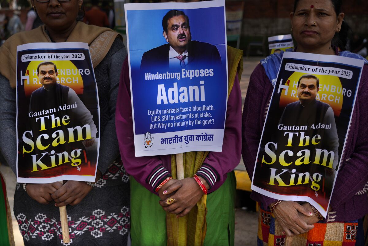 Members of opposition Congress party, demanding an investigation into allegations of fraud and stock manipulation by India's Adani Group hold placards with images of Indian businessman Gautam Adani during a protest in New Delhi, India, Monday, Feb.6, 2023. The Congress party urged people to protest, adding to pressure on Prime Minister Narendra Modi to respond to a massive sell-off of shares in Adani Group companies after a U.S.-based short-selling firm, Hindenburg Research, accused them of various fraudulent practices. The Adani group has denied any wrongdoing. (AP Photo/Manish Swarup)