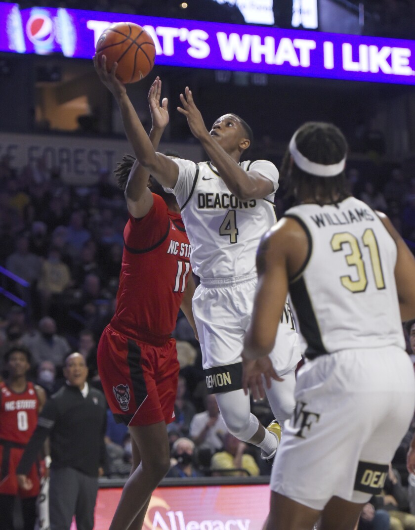 Wake Forest's Daivien Williamson gets past North Carolina State's Jaylon Gibson for a layup during an NCAA college basketball game Wednesday, March 2, 2022 in Winston Salem, N.C. (Walt Unks/The Winston-Salem Journal via AP)
