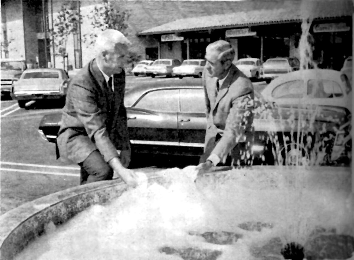 Plaza de La Cañada developer and owner Phil Kirst, right, and John Ivers of the Ivers department store family in October 1969 point out vandalism at a tiled fountain at the shopping center.