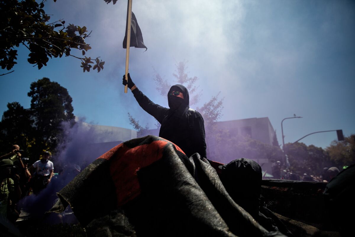 Members of the "black bloc" celebrate as they push into Martin Luther King Jr. Civic Center Park during a day of protests in Berkeley on Sunday.