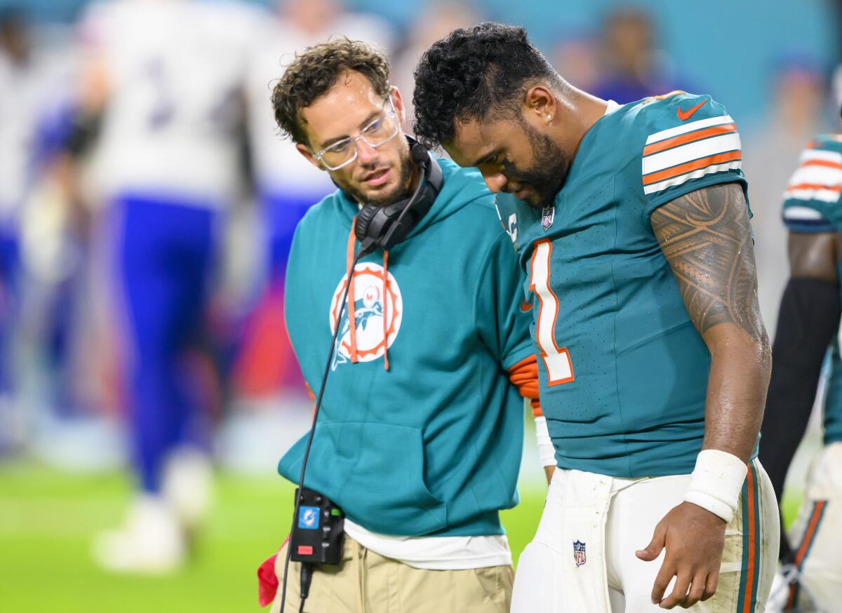 Miami Dolphins quarterback Tua Tagovailoa walks off of the field with head coach Mike McDaniel after suffering an injury