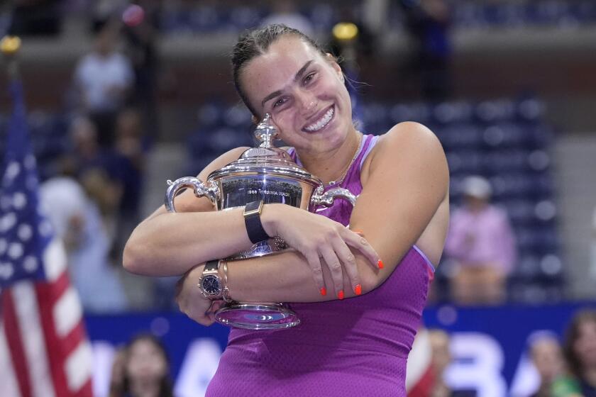 Aryna Sabalenka, of Belarus, hugs the trophy after winning the women's singles final.