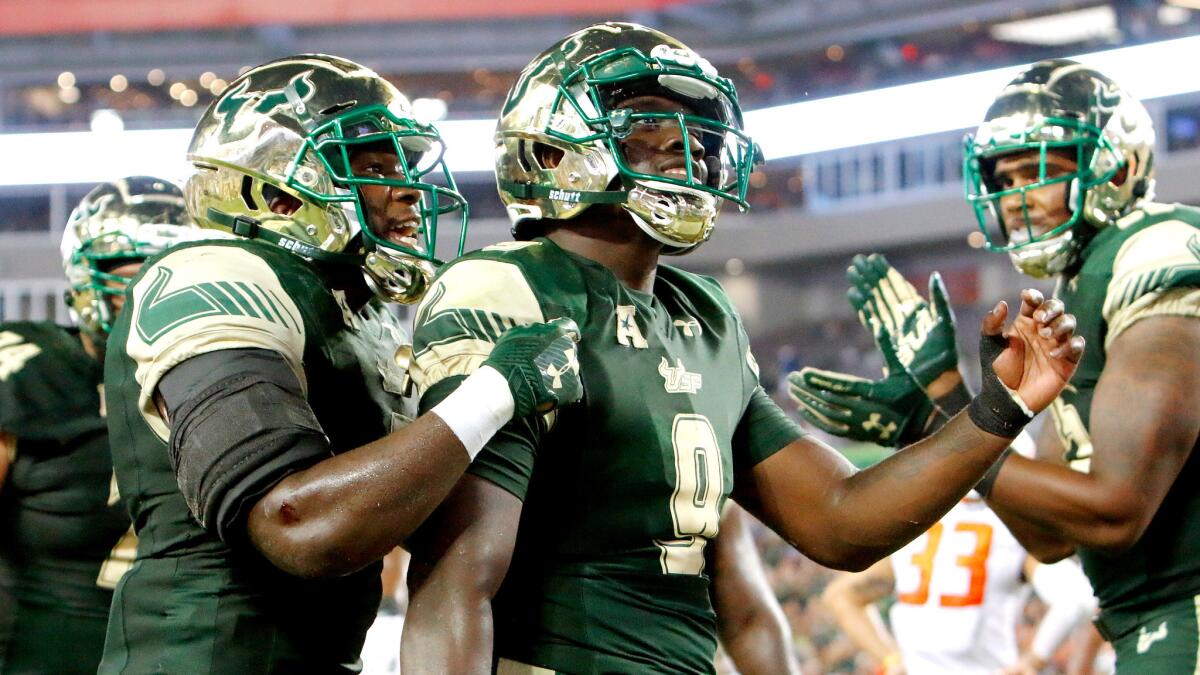South Florida quarterback Quinton Flowers (9) celebrates with teammates after scoring a touchdown against Illinois on a six-yard run Friday night.