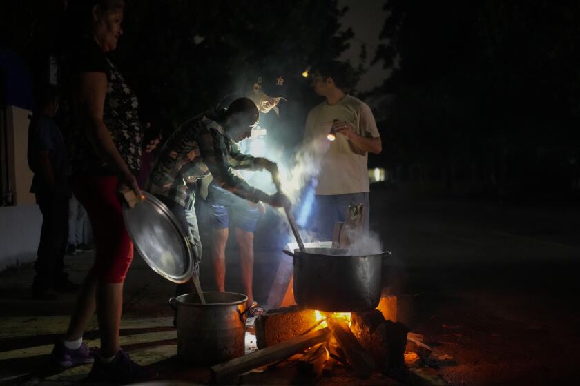 Personas preparan una sopa en una fogata durante un apagón que siguió a la falla de una importante planta energética en La Habana, Cuba, el sábado 19 de octubre de 2024. (AP Foto/Ramón Espinosa)