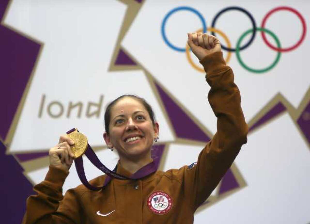 American Jamie Gray proudly displays her gold medal in the women's 50-meter rifle three-position shooting competition.