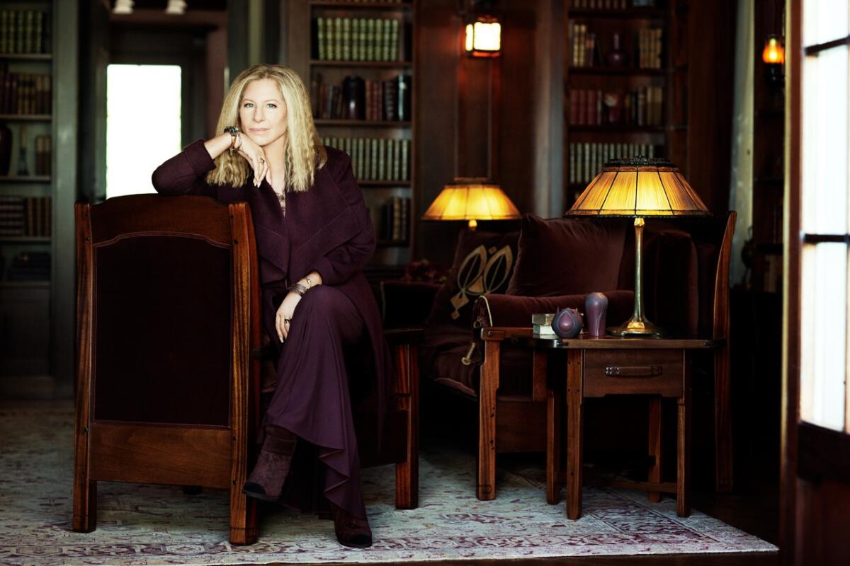 Barbra Streisand seated among some of her vintage furniture.