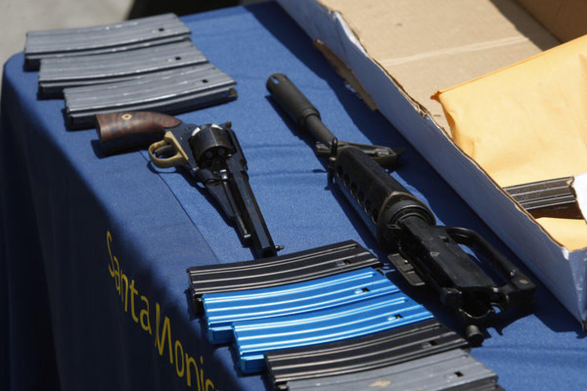 A pistol, part of an assault-style rifle and ammunition magazines allegedly dropped by a gunman during a mass shooting spree, are displayed at the Santa Monica Police Department headquarters earlier this month.