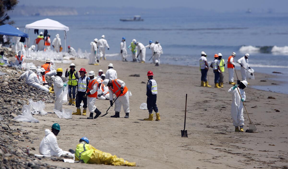 A beach cleanup crew at the shoreline of Refugio State Beach in Goleta on June 1. Lawmakers have proposed tougher rules to prevent spills.