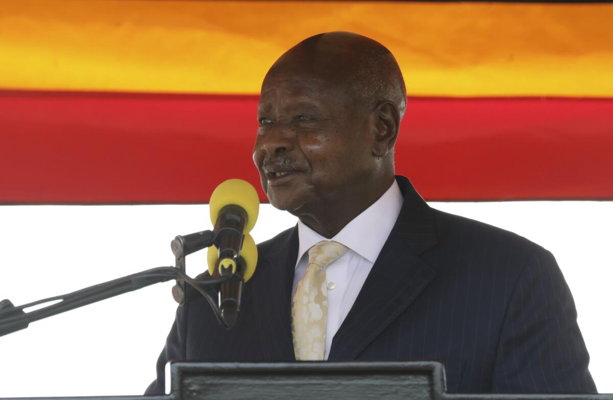 Yoweri Museveni speaks before two microphones 