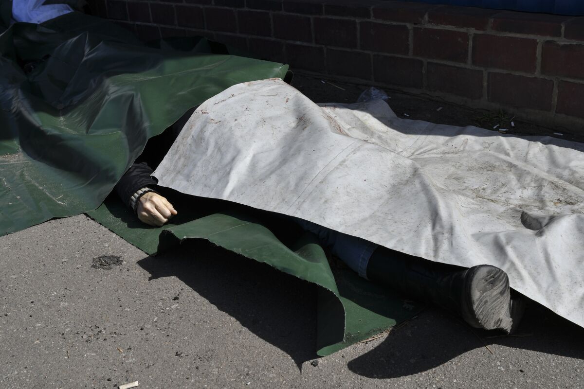 A body lies covered after Russian shelling at the railway station in Kramatorsk, Ukraine, Friday, April 8, 2022. Hours after warning that Ukraine's forces already had found worse scenes of brutality in a settlement north of Kyiv, President Volodymyr Zelenskyy said that "thousands" of people were at the station in Kramatorsk, a city in the eastern Donetsk region, when it was hit by a missile. (AP Photo/Andriy Andriyenko)