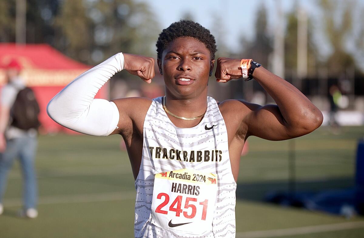 Long Beach Poly's Benjamin Harris flexes after winning the boys' 100 meters at the Arcadia Invitational.